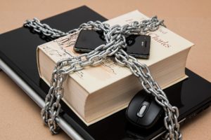 laptop and book with padlock and chain